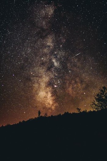 silhouette of the mountain under the starry skies
