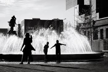Silhouette of Three People In front of a Fountain