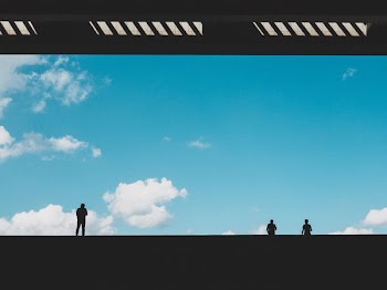 silhouette of three person against blue sky