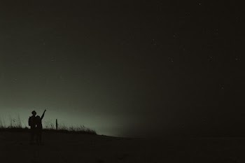 silhouette of two people looking at stars