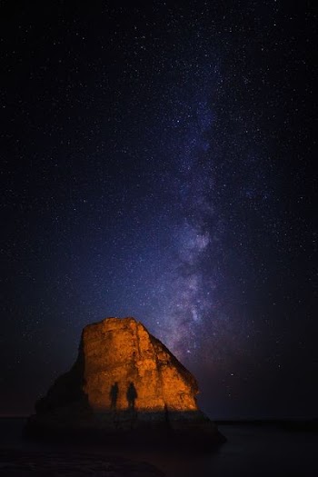 silhouette of two person near stone photo