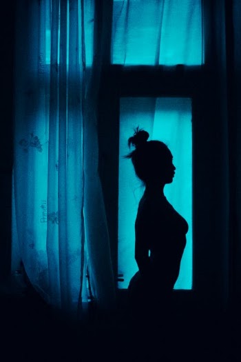Silhouette of unrecognizable sensual woman near window at home · Free Stock Photo