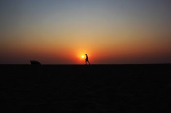 silhouette of walking man under sunset
