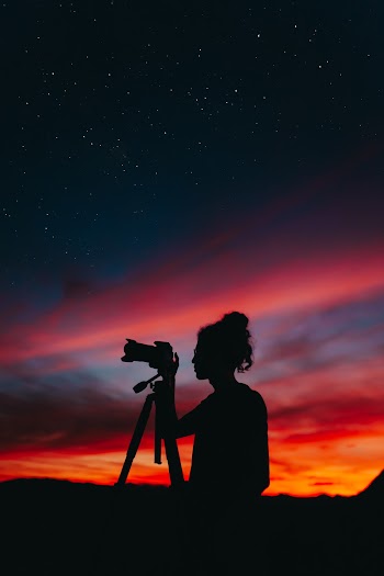 Silhouette of Woman Holding Camera at Night