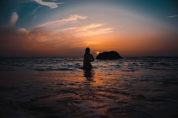 Silhouette of Woman On Ocean During Sunset