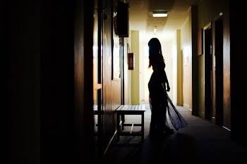 silhouette of woman standing beside bench