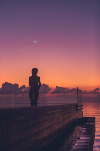 Silhouette of Woman Standing Beside Rail Near Outdoor