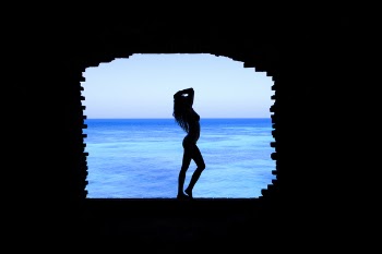 Silhouette of Woman Standing Between Walls