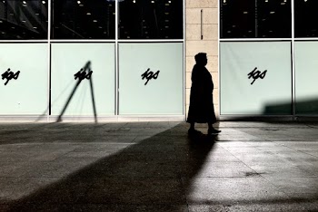 Silhouette of Woman Walking Beside Building