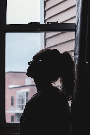 Silhouette Photo of a Woman Looking Through Window