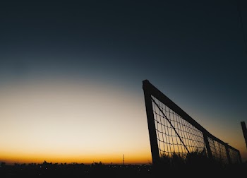 Silhouette Photo of Fence During Dawn