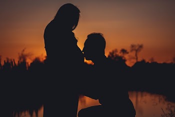 Silhouette Photo of Man Kissing His Wife Pregnant Stomach
