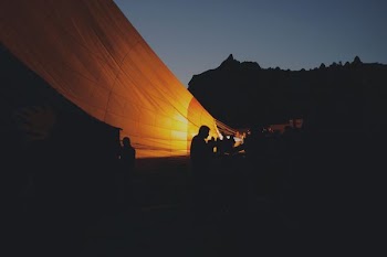 silhouette photo of people sitting near orange cover