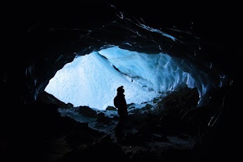 Silhouette Photo of Person Standing in Cave