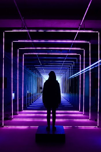Silhouette Photo of Person Standing in Neon Lit Hallway