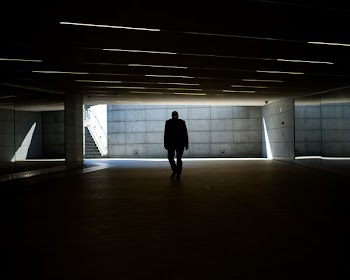 silhouette photo of person walking inside dark room
