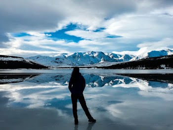 Silhouette Photo of Woman Facing Snow Capped Mountain