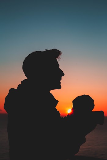 Silhouette Photography of Man Holding Baby