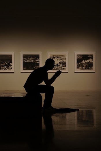 Silhouette Photography of Man Sitting on Bed