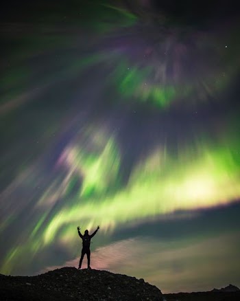 silhouette photography of man standing under sky phenomenon