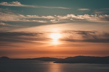 Silhouette Photography of Mountain Under a Cloudy Sky During Golden Hour