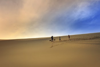 Silhouette Photography Of Three People Walking On Sand