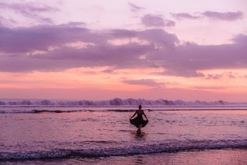 Silhouette Photography of Woman Standing on Body of Water