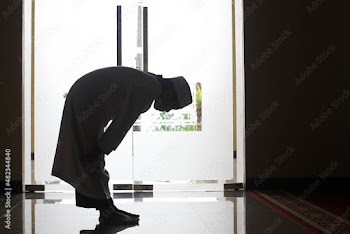 Silhouette side view of boy  doing salat at the mosque with rukuk posed or bend down