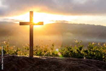 Silhouettes of crucifix symbol with bright sunbeam on the colorful sky background