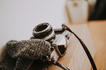 silver and black SLR camera on brown table