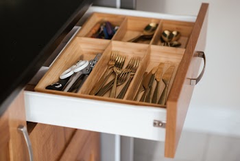 Silver-colored Cutlery Set on Brown Wooden Dresser
