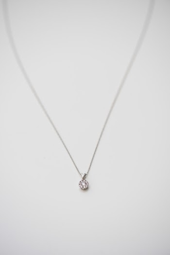 Silver-colored Pendant Necklace in Selective Focus Photography