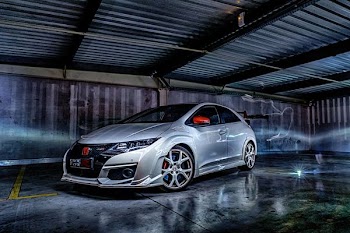 silver Honda 3-door hatchback inside gray garage