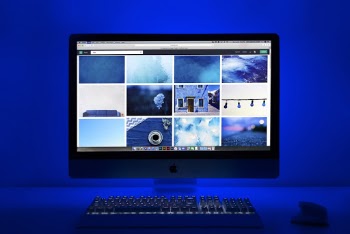 Silver Imac Turned on Displaying Different Photos