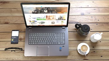 Silver Laptop Next to Coffe Cup Smartphone and Glasses