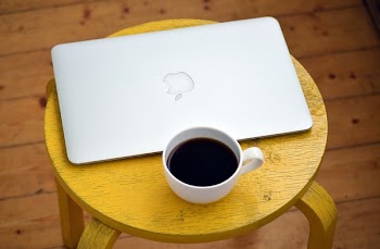 Silver Macbook Beside White Cup