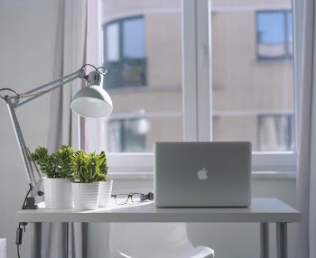 silver MacBook on top of white wooden desk