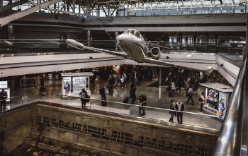 Silver Plane on Display in Museum With People