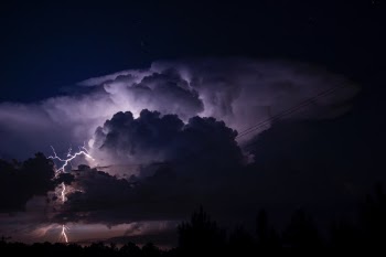 Single cell thunderstorm cloud to ground strike with impressive illuminated structure. 