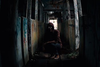 sitting man on abandoned building during daytime