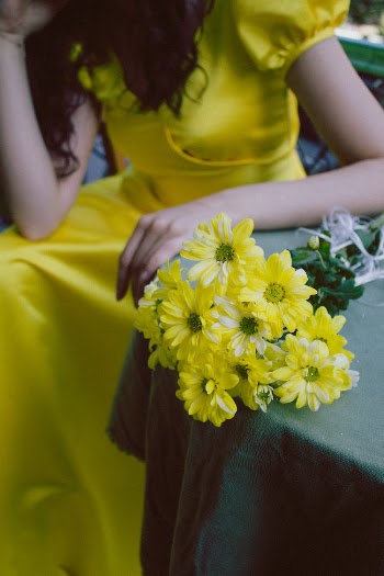 Sitting Woman Leaning Hand on Table with Bouquet