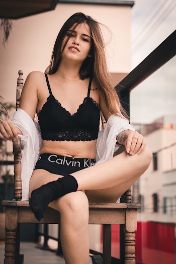 Sitting Woman Wearing Black Calvin Klein Pantie Crossing Leg