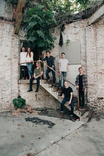 six men and a woman standing on stair white taking picture