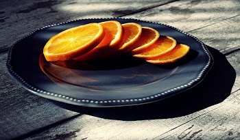 Six Slices of Oranges on Black Ceramic Plate
