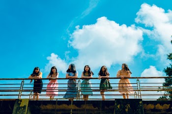 Six Women Wearing Mini Dresses Leaning on Bridge's Rail