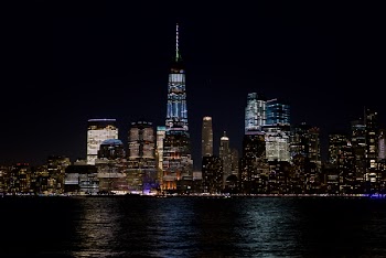 Skyline Beside the Body of Water at Night Time