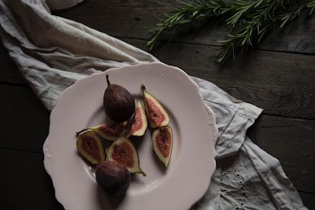 sliced fruit on plate beside green leaves