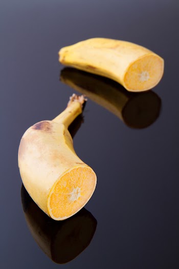 Sliced Into Two Riped Banana on Black Surface