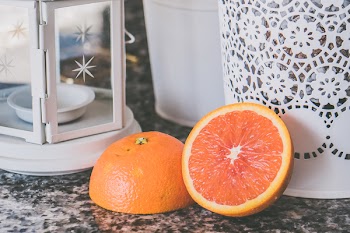 Sliced of Orange Fruit Near on White Framed Glass Candle Lantern