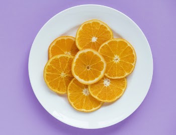 Sliced Orange Fruits on Round White Ceramic Plate